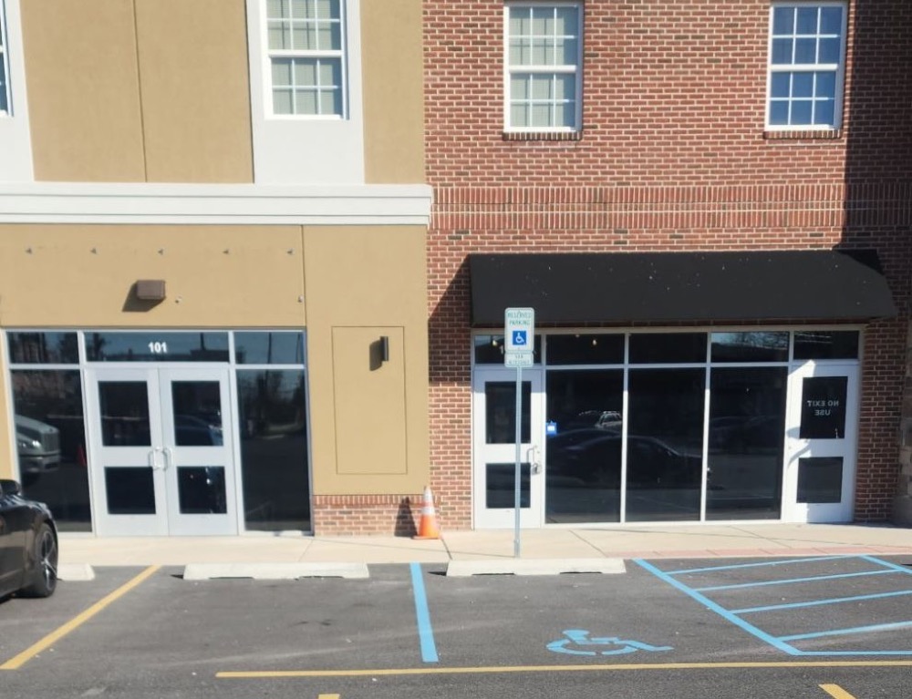 Commercial storefront with tinted glass windows and doors in daylight